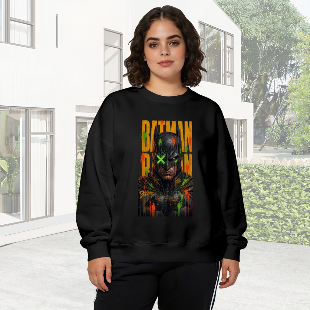 Outdoor photograph of a model in a women's crewneck sweatshirt bearing a tall graffiti-style cowl portrait with a green X across the eyes