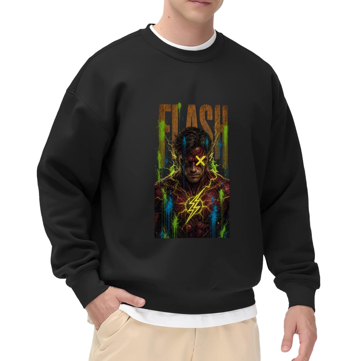 Studio photograph of a model in a men's crewneck sweatshirt showing a masked graffiti portrait with a yellow X and lightning marks