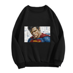 Front garment photograph: women's crewneck sweatshirt decorated with a tightly cropped intense face above a cape against newsprint