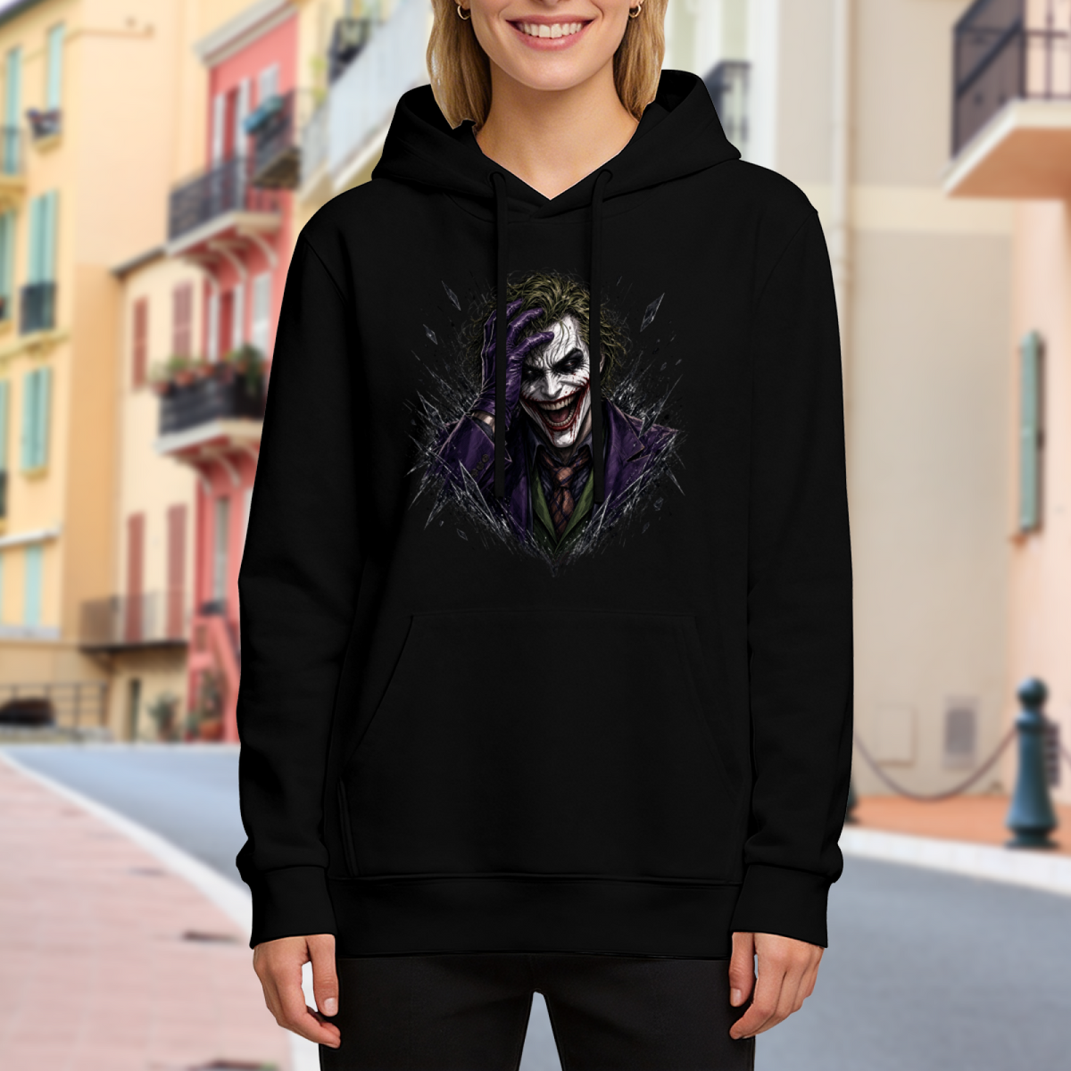 On-location model photograph displaying a grinning clown portrait framed by rough dark strokes on the front of a women's hoodie