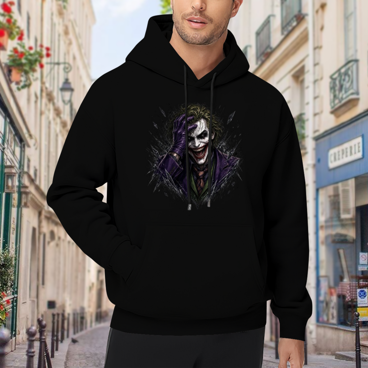 Men's hoodie worn outside, with the camera facing the graphic of a grinning clown portrait framed by rough dark strokes