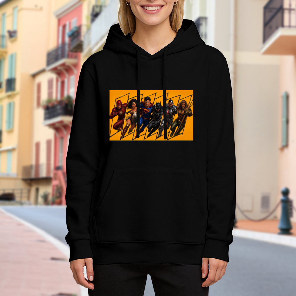 A group of costumed figures charging across a warm-toned action panel visible on a women's hoodie in an outdoor front model view