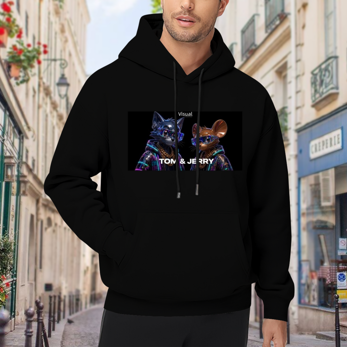 Outdoor photograph of a model in a men's hoodie bearing a cartoon cat and mouse against a neon-toned backdrop
