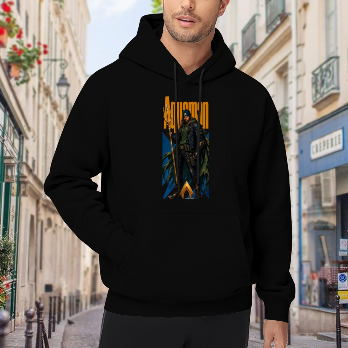 A hooded figure gripping a trident in a tall street-style composition visible on a men's hoodie in an outdoor front model view