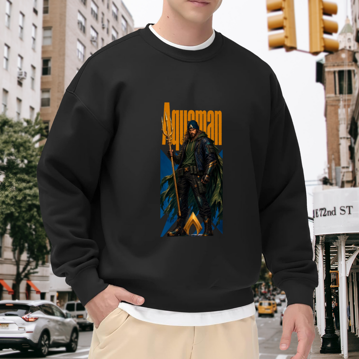 On-location model photograph displaying a hooded figure gripping a trident in a tall street-style composition on the front of a men's crewneck sweatshirt