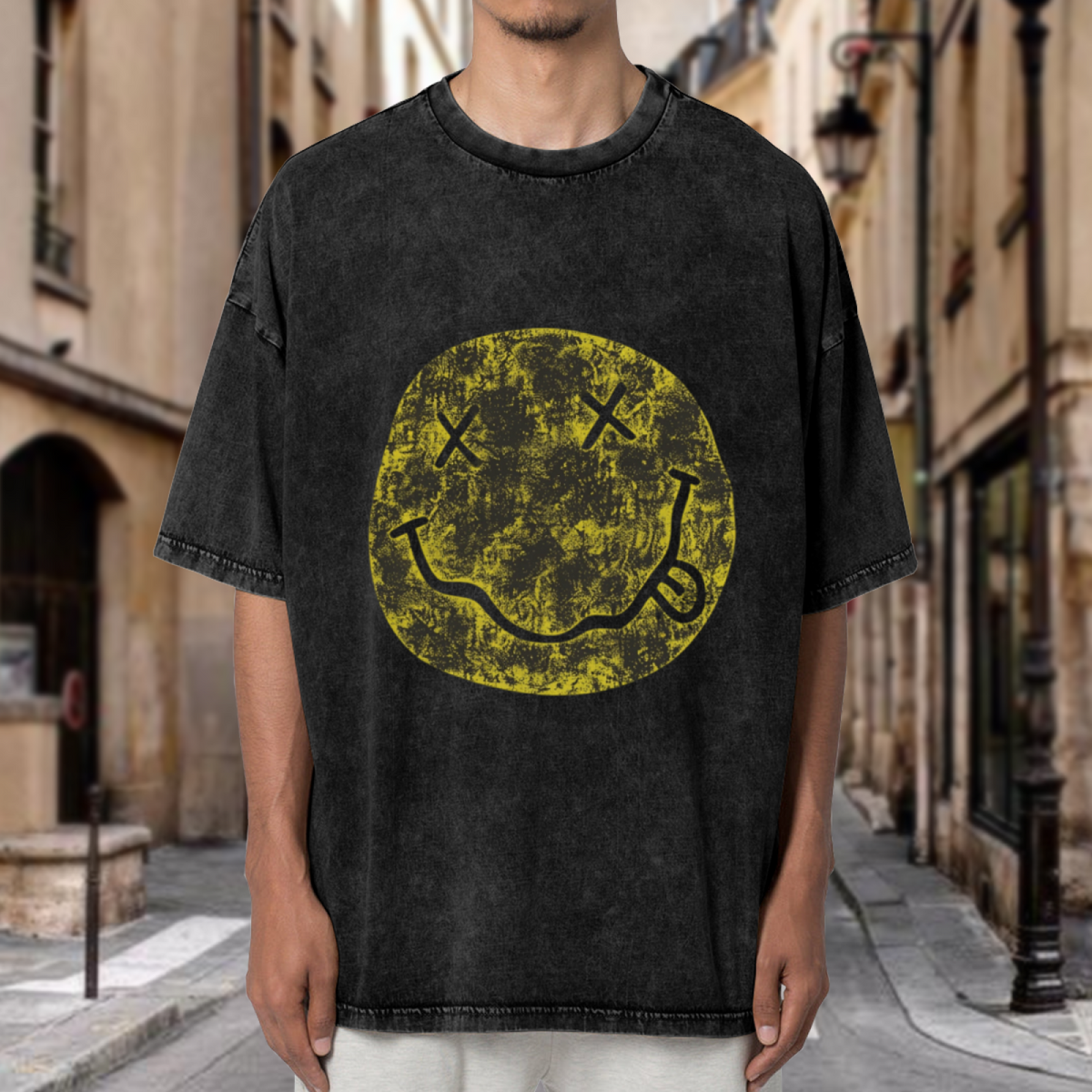Nirvana Distressed Smiley Washed Graphic Tee in Black, product image showing a faded yellow Nirvana smiley-face graphic with a distressed finish.