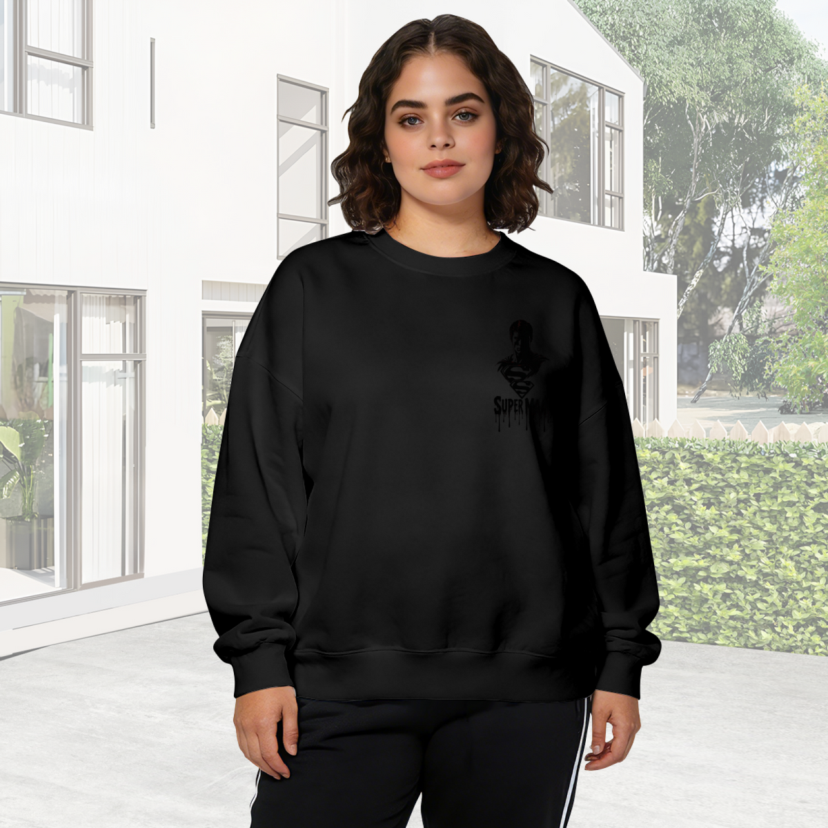 On-location model photograph displaying a small caped ink silhouette with lettering on the front of a women's crewneck sweatshirt