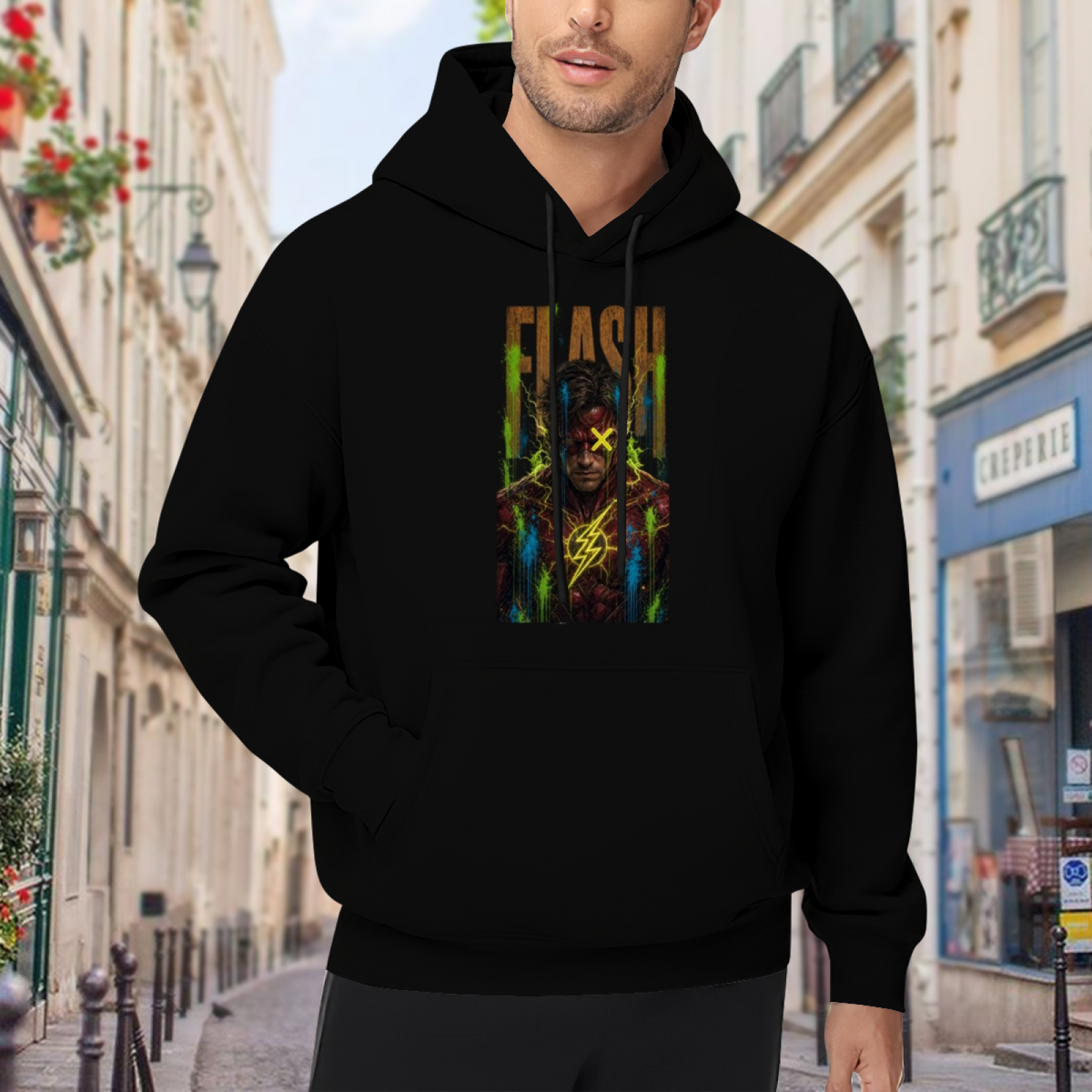 Outdoor photograph of a model in a men's hoodie bearing a masked graffiti portrait with a yellow X and lightning marks