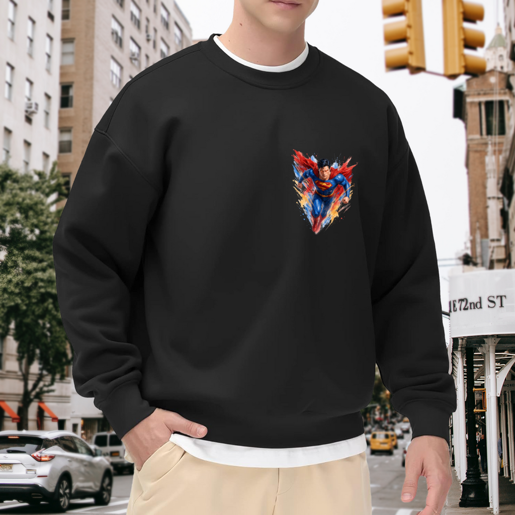 On-location model photograph displaying a flying caped figure amid sharp multicolored brushstrokes on the front of a men's crewneck sweatshirt