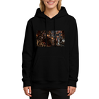 Front-facing model wearing a women's hoodie decorated with a feline throne scene with gathered figures and warm firelight