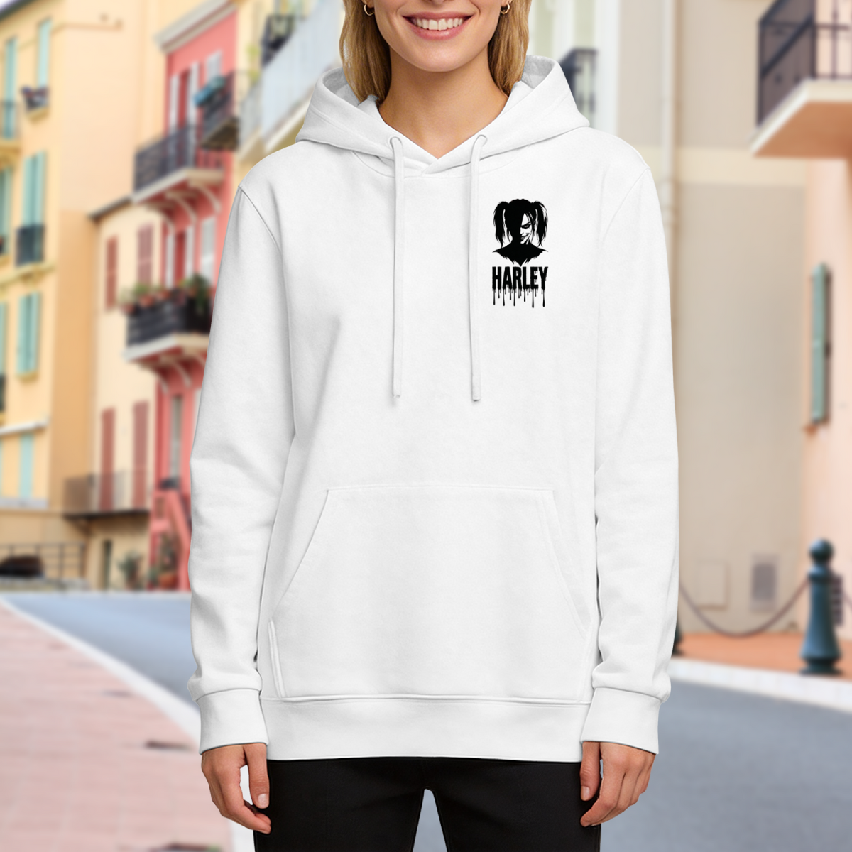 Lifestyle image outdoors: women's hoodie with a front graphic of a compact pigtail silhouette with ink-style lettering