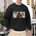 A long-haired ocean warrior in armor against newspaper-style lettering visible on a men's crewneck sweatshirt in an outdoor front model view