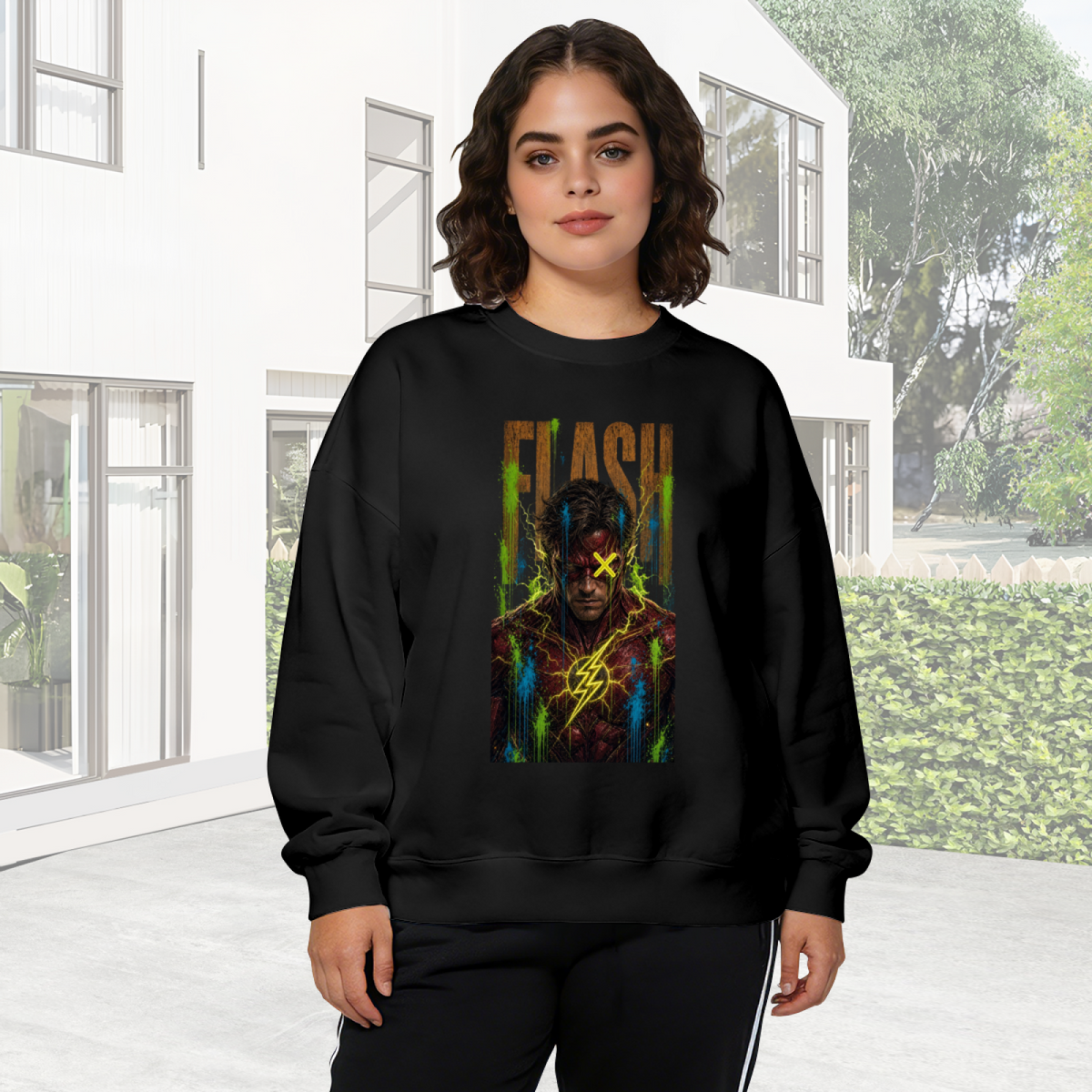 On-location model photograph displaying a masked graffiti portrait with a yellow X and lightning marks on the front of a women's crewneck sweatshirt