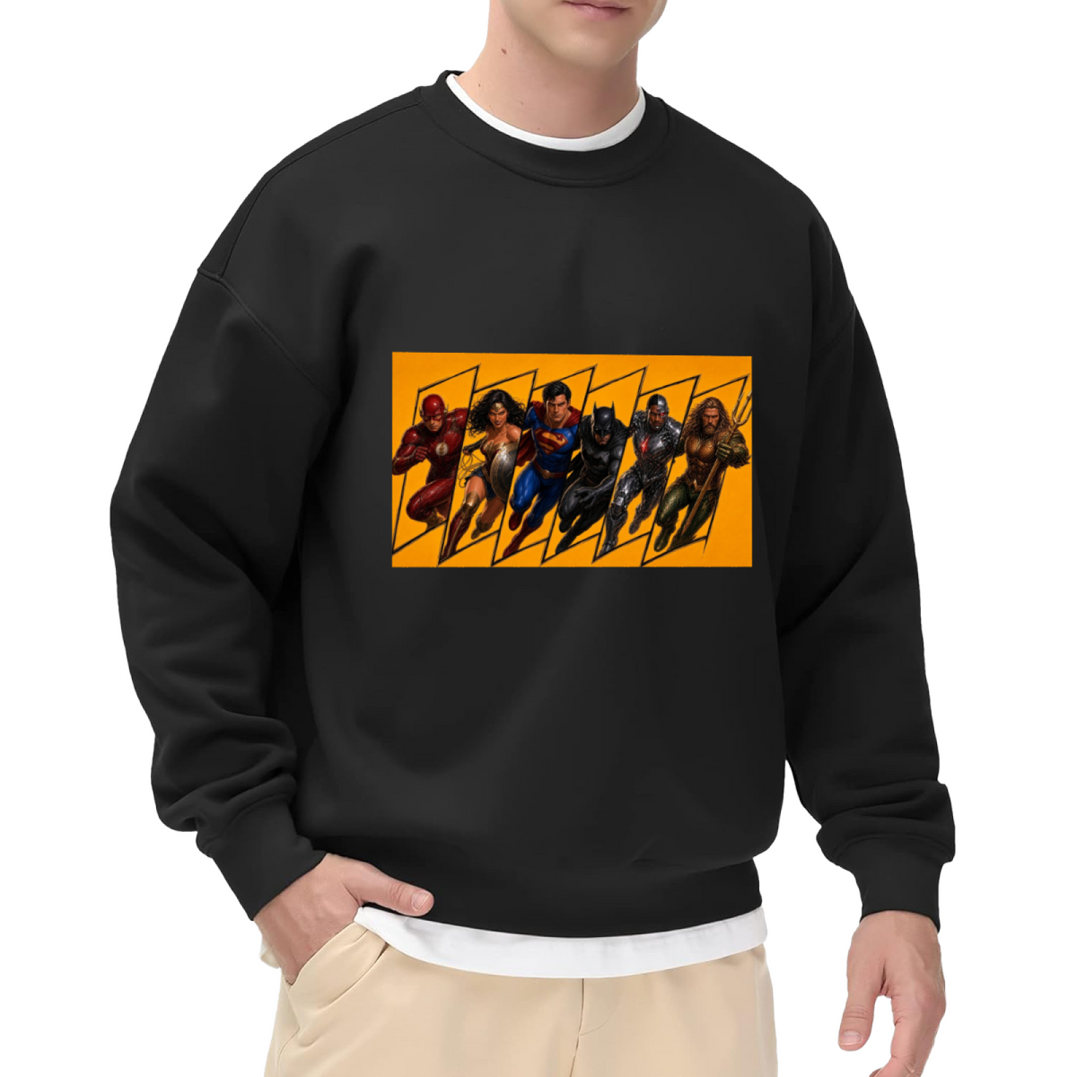 Studio photograph of a model in a men's crewneck sweatshirt showing a group of costumed figures charging across a warm-toned action panel
