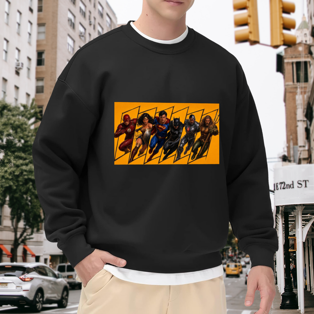 Men's crewneck sweatshirt worn outside, with the camera facing the graphic of a group of costumed figures charging across a warm-toned action panel