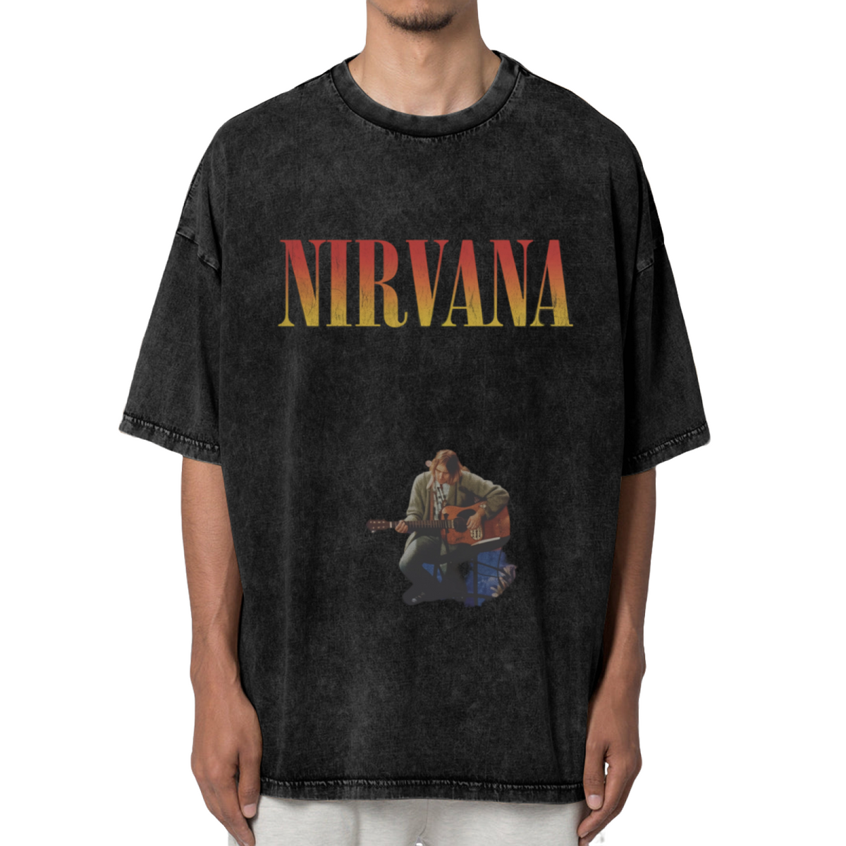 Nirvana Kurt Cobain Acoustic Washed Tee in Black, product image showing kurt Cobain seated with an acoustic guitar, with a Nirvana logo above the performance image.