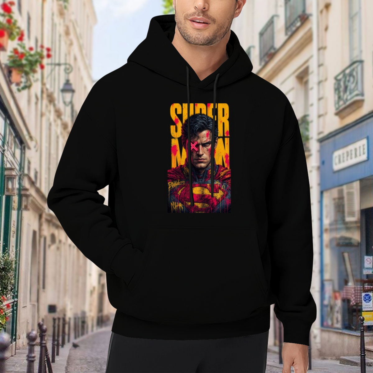 Men's hoodie worn outside, with the camera facing the graphic of a tall caped graffiti portrait with a pink X across the eyes