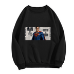 Unworn women's crewneck sweatshirt, front view of the design depicting a classic caped figure posed against a rectangular newspaper-style collage