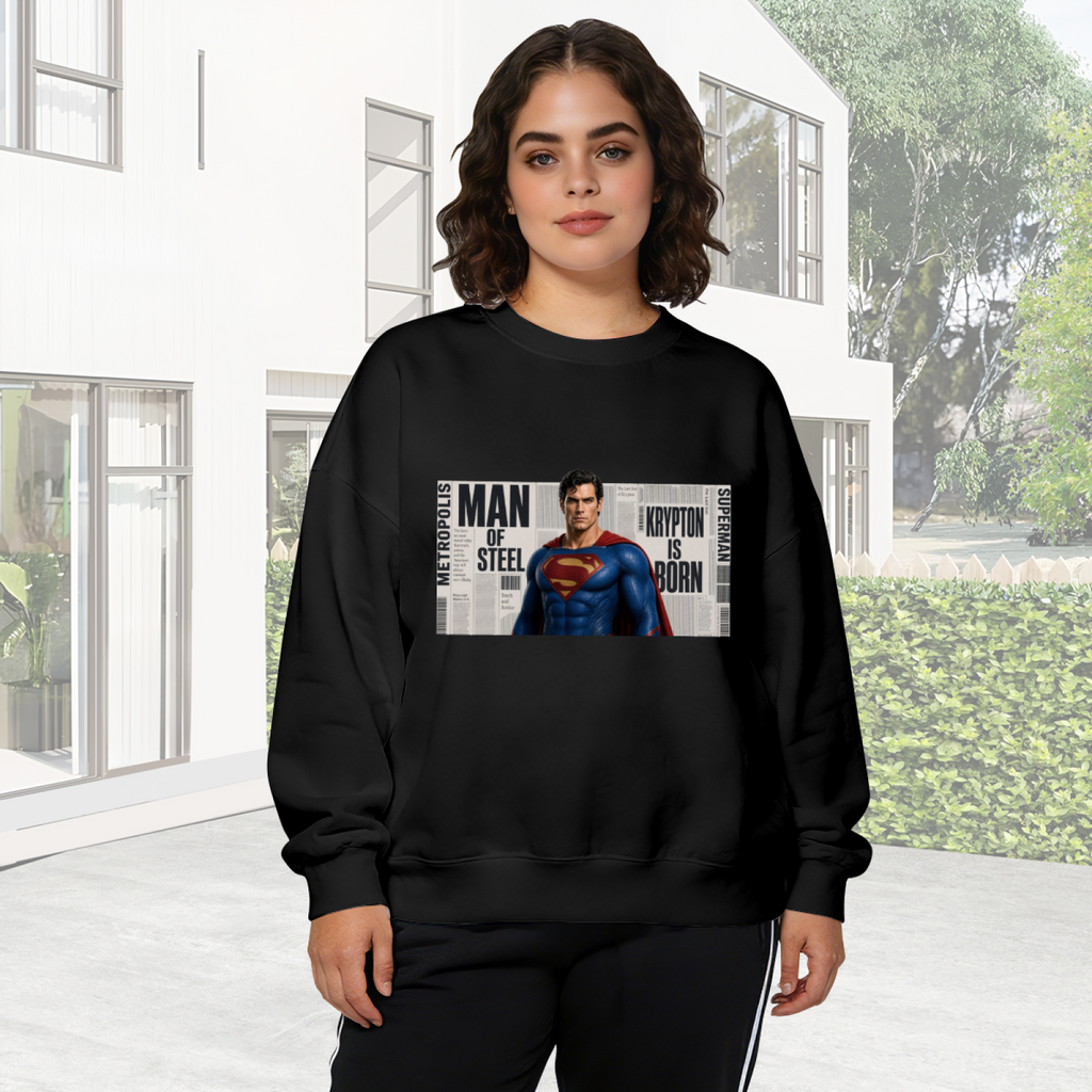 On-location model photograph displaying a classic caped figure posed against a rectangular newspaper-style collage on the front of a women's crewneck sweatshirt